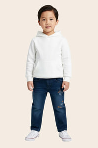 Young boy wearing denim straight jeans from Denimden Boys Collection, suitable for ages 2 to 4 years, in a casual outdoor setting.